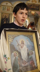 Ученик воскресной школы готовится к крестному ходу с иконой Воскресение Господне